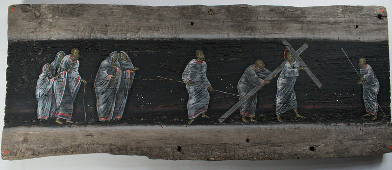 Vanhalle puulankulle maalattu kuva Jeesuksesta kantamassa ristiä ja häntä seuraavista ihmisistä.